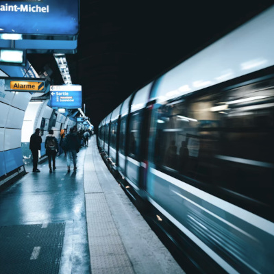 A Paris Metro train pulling into a station at night.